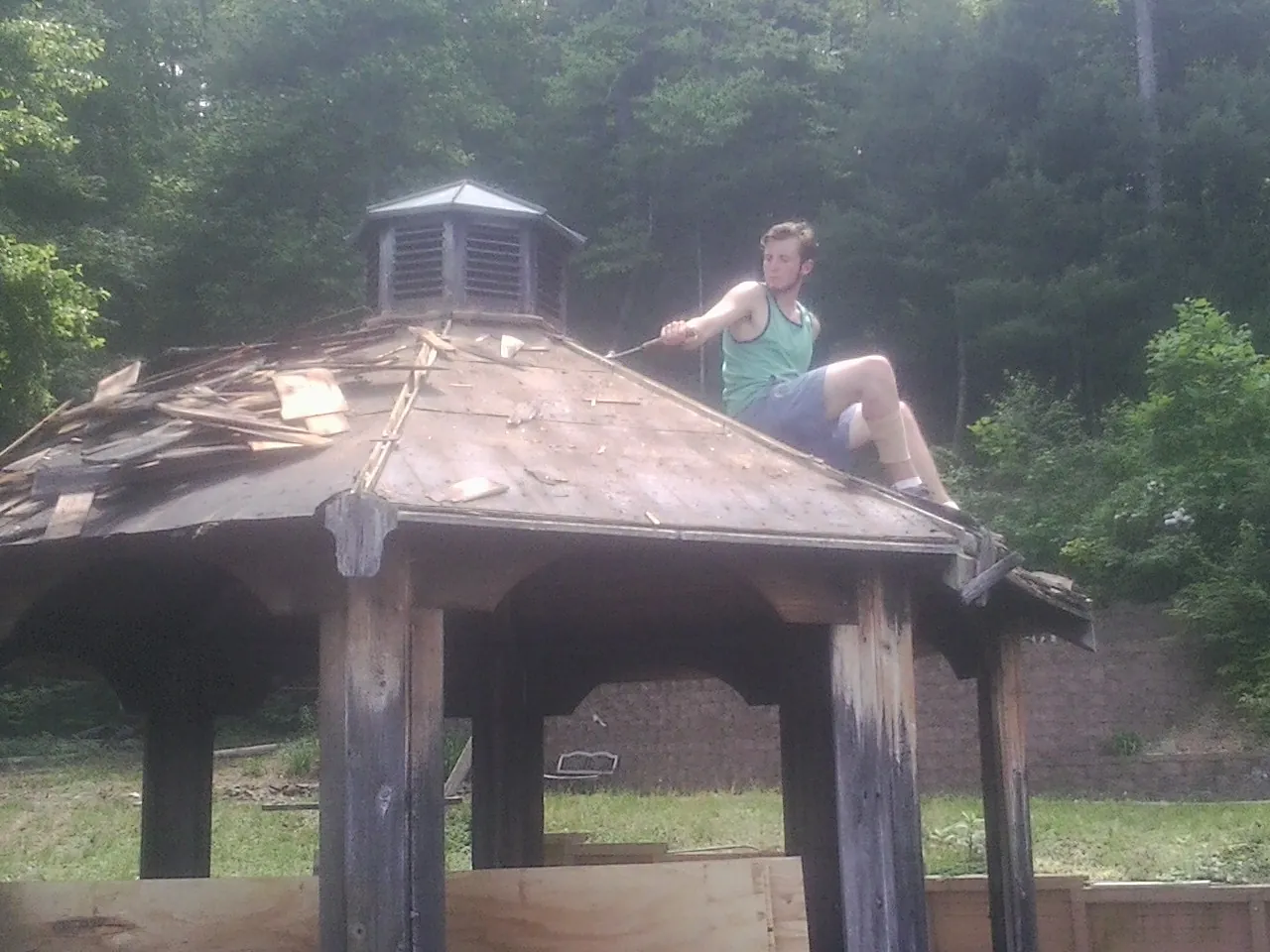Tearing the old roof off a wooden gazebo before new shakes in Beaumont