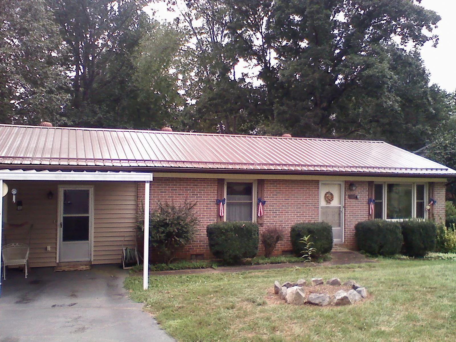 Bronze metal roof and carport on a brick ranch home — Roof Repair work by our crew in Beaumont